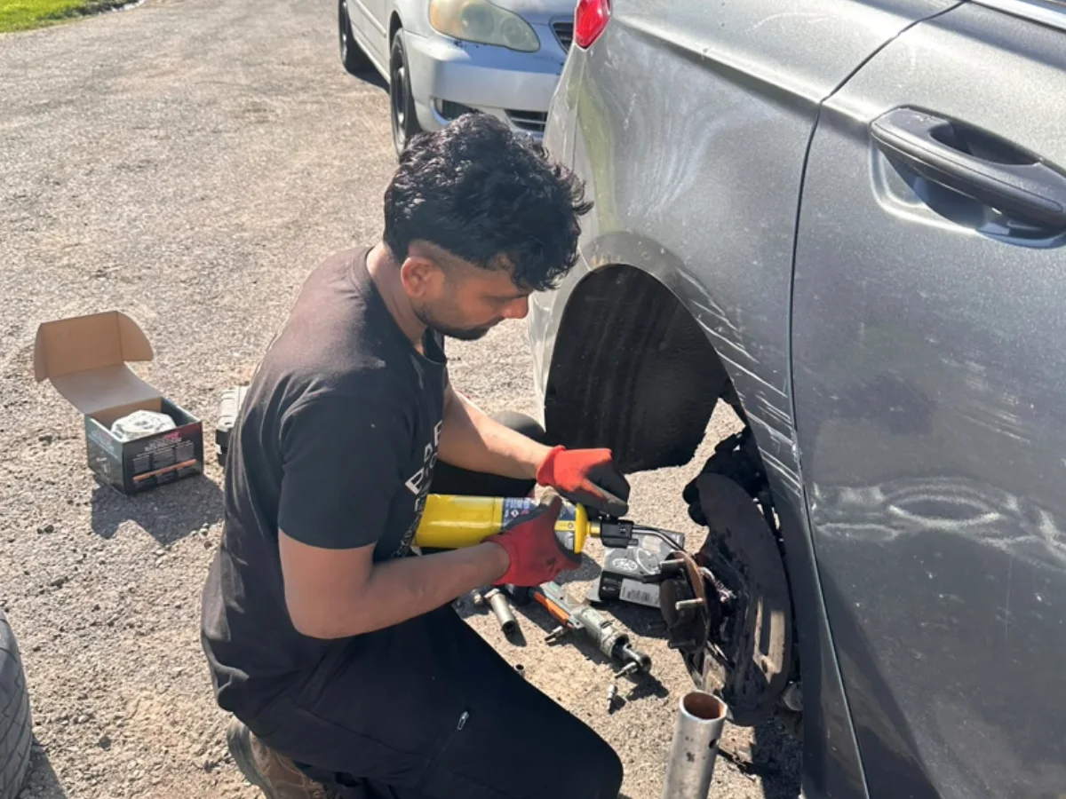 Babbal working beside a vehicle during a mobile service visit