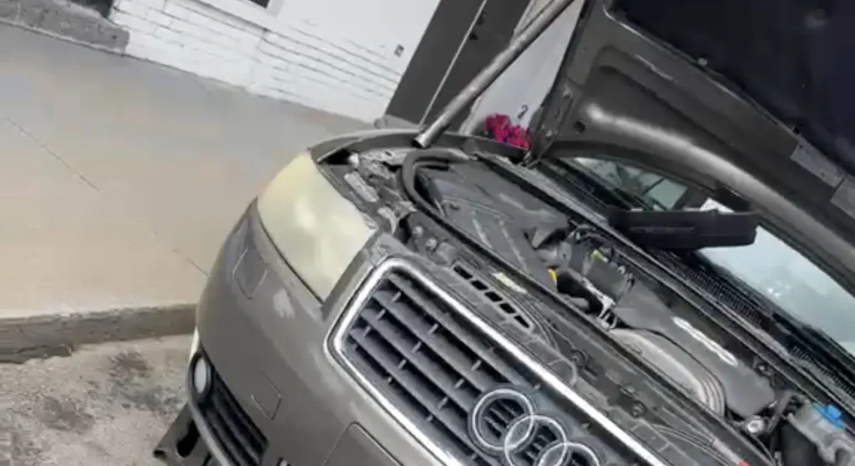 Open vehicle hood with tools visible during real work